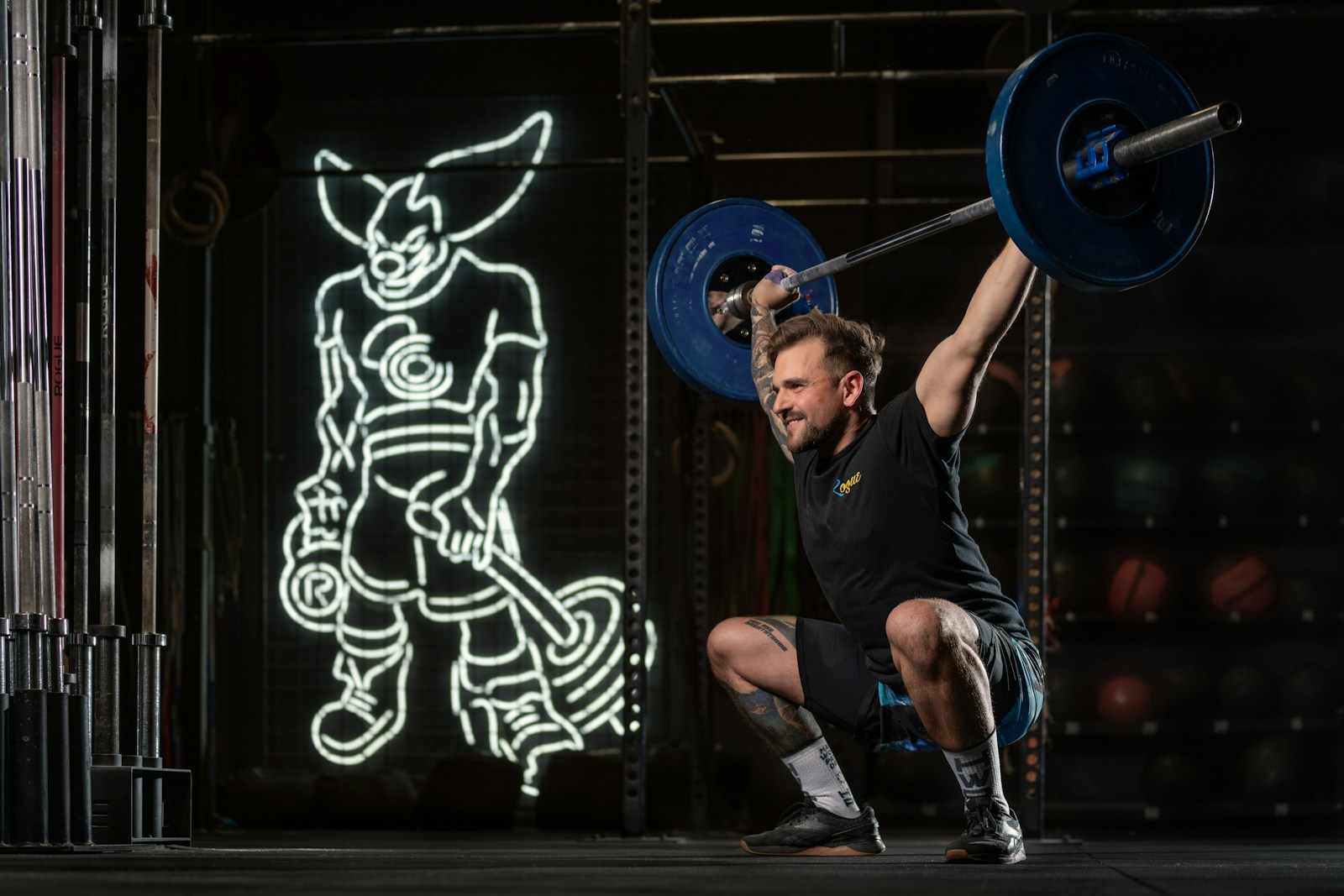 a man squatting with a barbell in his hands