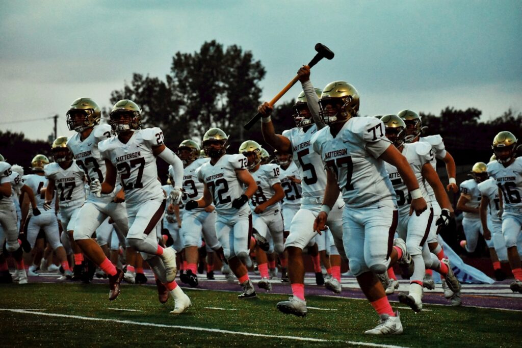 a football team running onto the field